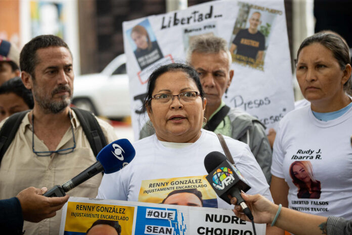 La mamá del detenido, Renny González, Lourdes García (c), habla durante una rueda de prensa este jueves, frente al Ministerio Público, en Caracas (Venezuela). Familiares de presos políticos protestan frente al Ministerio Público para exigir la liberación de los presos acusados por terrorismo y vinculados con las Tancol, acrónimo acuñado por las autoridades venezolanas para referirse a 'terroristas armados narcotraficantes colombianos'. EFE/ Ronald Peña R
