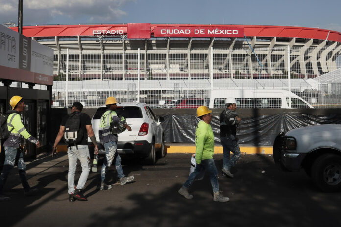 Trabajadores caminan frente al estadio Ciudad de México este miércoles, en Ciudad de México (México). EFE/ José Méndez
