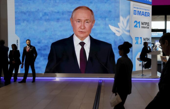 Los participantes pasan junto a una gran pantalla que muestra una imagen del presidente ruso, Vladímir Putin, durante el Foro Económico Internacional de San Petersburgo (SPIEF), en San Petersburgo, Rusia, el 04 de junio de 2026. El 29º SPIEF se celebra del 03 al 06 de junio de 2026. (Rusia, San Petersburgo) EFE/EPA/ANATOLY MALTSEV
