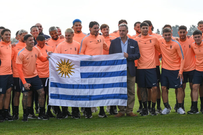 El presidente de Uruguay, Yamandú Orsi (c), posa junto a jugadores de la selección de fútbol durante la entrega del pabellón nacional en Montevideo (Uruguay). EFE/ Federico Gutiérrez
