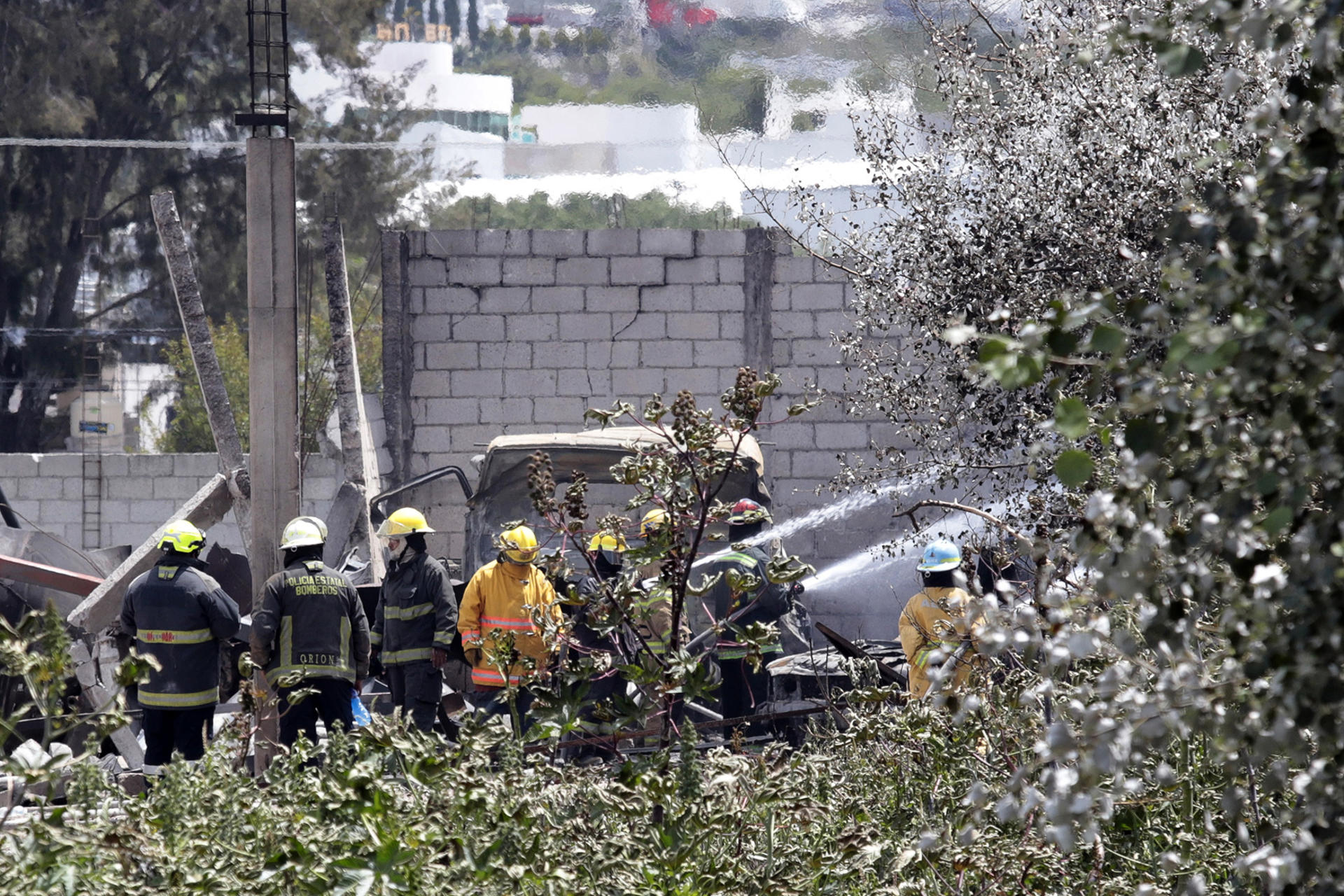 Integrantes de Bomberos controlan un incendio este jueves, en el municipio de Tepeaca, Puebla (México). Una explosión de una bodega donde se almacenaban cisternas de Gas Licuado de Petróleo (GLP) dejó el saldo de tres heridos. EFE/ Hilda Ríos