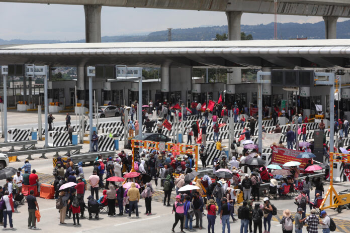 Integrantes de la Coordinadora Nacional de Trabajadores de la Educación (CNTE) se toman un peaje durante una manifestación este jueves, en la ciudad de México (México). EFE/ Madla Hartz
