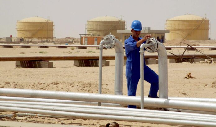 Un operario abre una válvula en una refinería de Najaf, en Irak, en una imagen de archivo. EFE/Hussein Al-Mousawi
