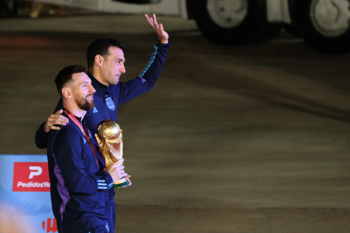 Fotografía de Raúl Martínez, en la que puede verse en una imagen de archivo del 19 de diciembre de 2022 al capitán de la selección argentina de fútbol, Lionel Messi (i), y al seleccionador de la Albiceleste, Lionel Scaloni (d), con el trofeo de la Copa del Mundo logrado en Catar 2022, a su llegada al Aeropuerto Internacional Ministro Pistarini, en Ezeiza (provincia de Buenos Aires) tras el torneo. EFE
