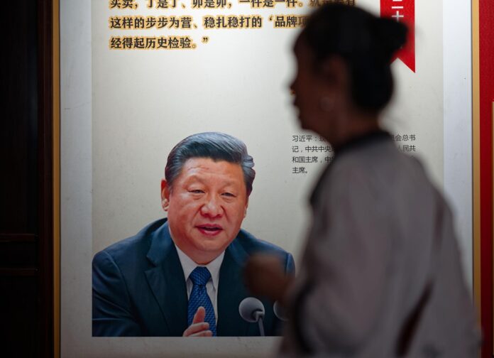 Fotografía de archivo, tomada el 27/05/2026, que muestra a una persona caminando cerca de un afiche del presidente d China, Xi Jinping. EFE/EPA/ALEX PLAVEVSKI
