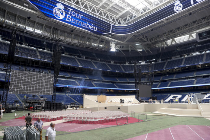 Decenas de personas participan en el montaje de escenarios para el encuentro del Papa León XIV con la Comunidad Diocesana en el Estadio Santiago Bernabéu, este viernes en Madrid. EFE/ Victor Lerena
