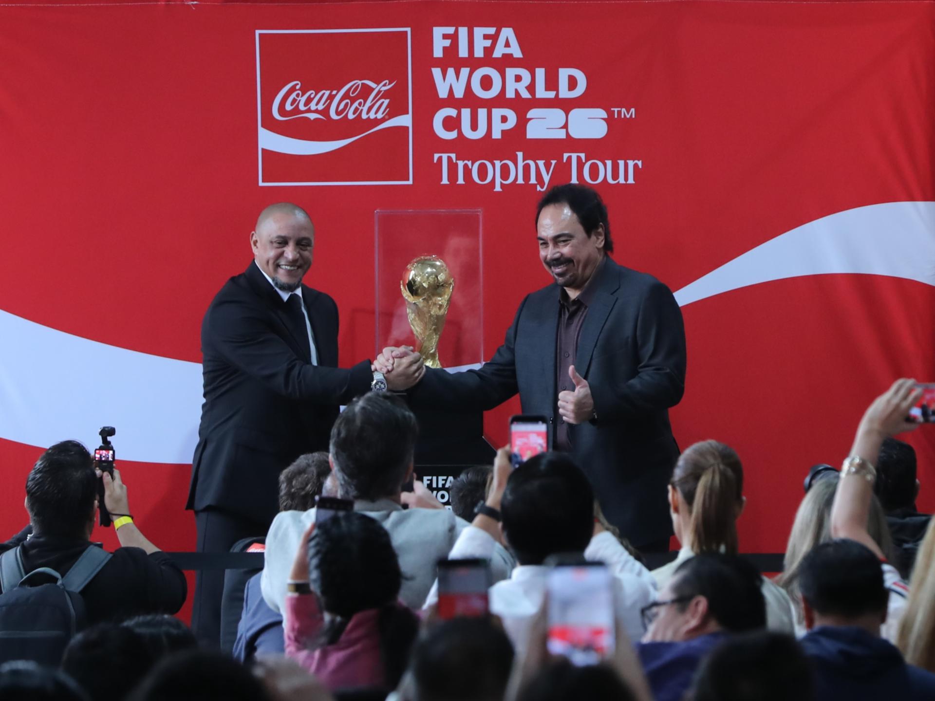 El exjugador brasileño Roberto Carlos (i) acompañado del mexicano Hugo Sánchez, muestran la Copa del Mundial 2026 este viernes, durante un evento en la Ciudad de México (México). EFE/ Mario Guzmán
