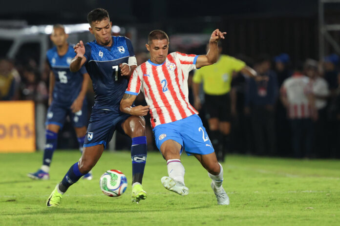 Gustavo Velázquez (d), de Paraguay, disputa un balón con Aaron Smith, de Nicaragua, en un partido amistoso entre Paraguay y Nicaragua previo a la Copa Mundial de Fútbol 2026 en el estadio Defensores del Chaco en Asunción (Paraguay). EFE/ Juan Pablo Pino
