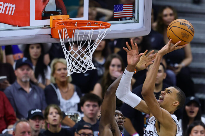 Victor Wembanyama (d), de los Spurs, lanza el balón en el segundo partido de las finales de la NBA entre San Antonio Spurs y New York Knicks en el estadio Frost Bank Center en San Antonio (Estados Unidos). EFE/ Carlos Ramírez
