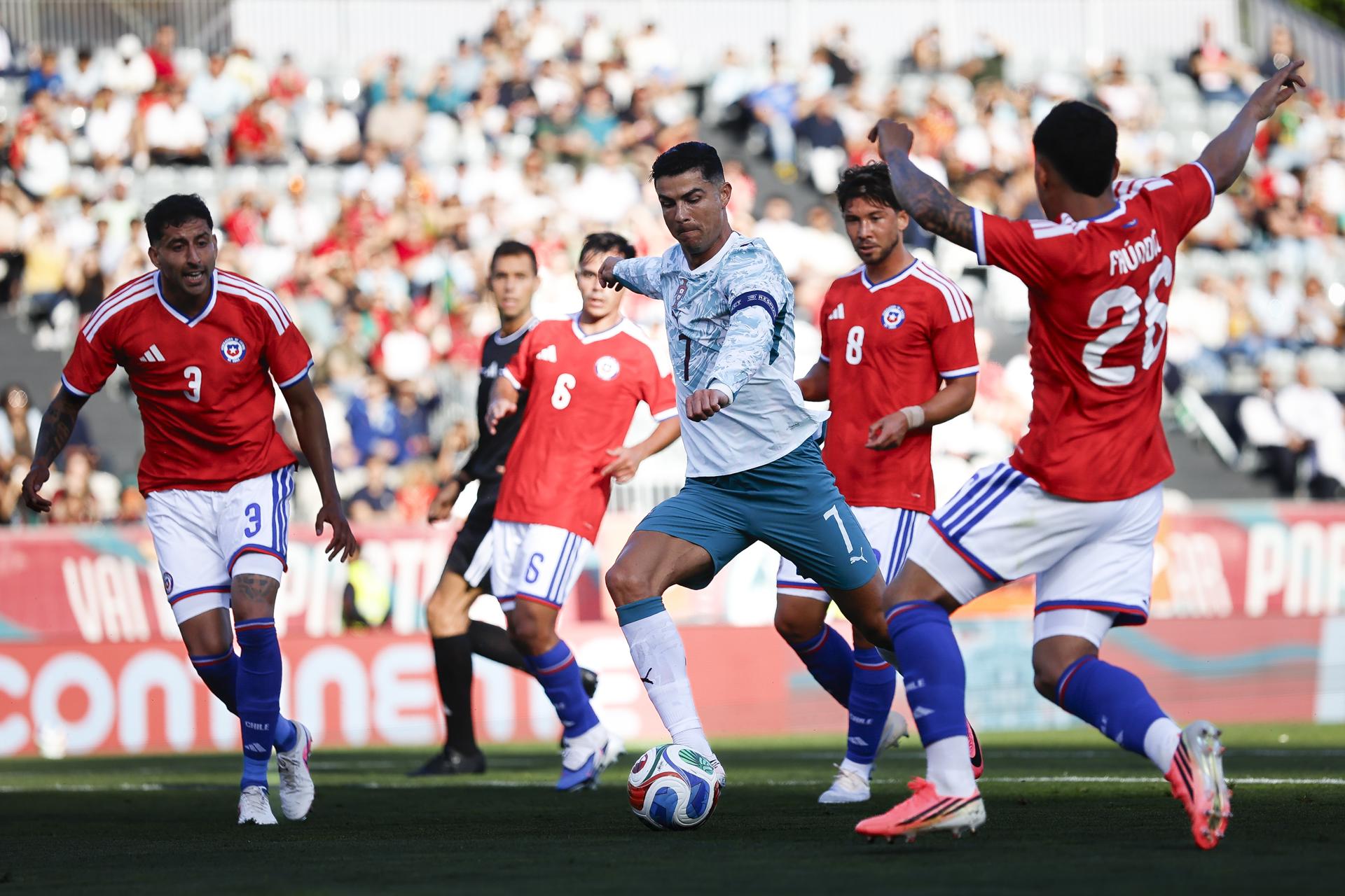 El jugador portugués Cristiano Ronaldo (C) en acción frente al chileno Felipe Faúndez (D) durante el partido amistoso internacional de fútbol entre Portugal y Chile celebrado en el Estadio Nacional, en Oeiras. EFE/EPA/FILIPE AMORIM
