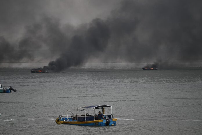 Fotografía de dos embarcación incendiándose este 6 de junio de 2026, en el puerto de Manta (Ecuador). EFE/ Ariel Ochoa
