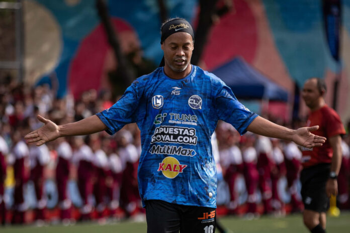 El exfutbolista brasileño Ronaldinho recibe la ovación del público este sábado en un partido de exhibición en Petare, la barriada más grande de Venezuela, como parte de la Liga Monumental. EFE/ Ronald Peña
