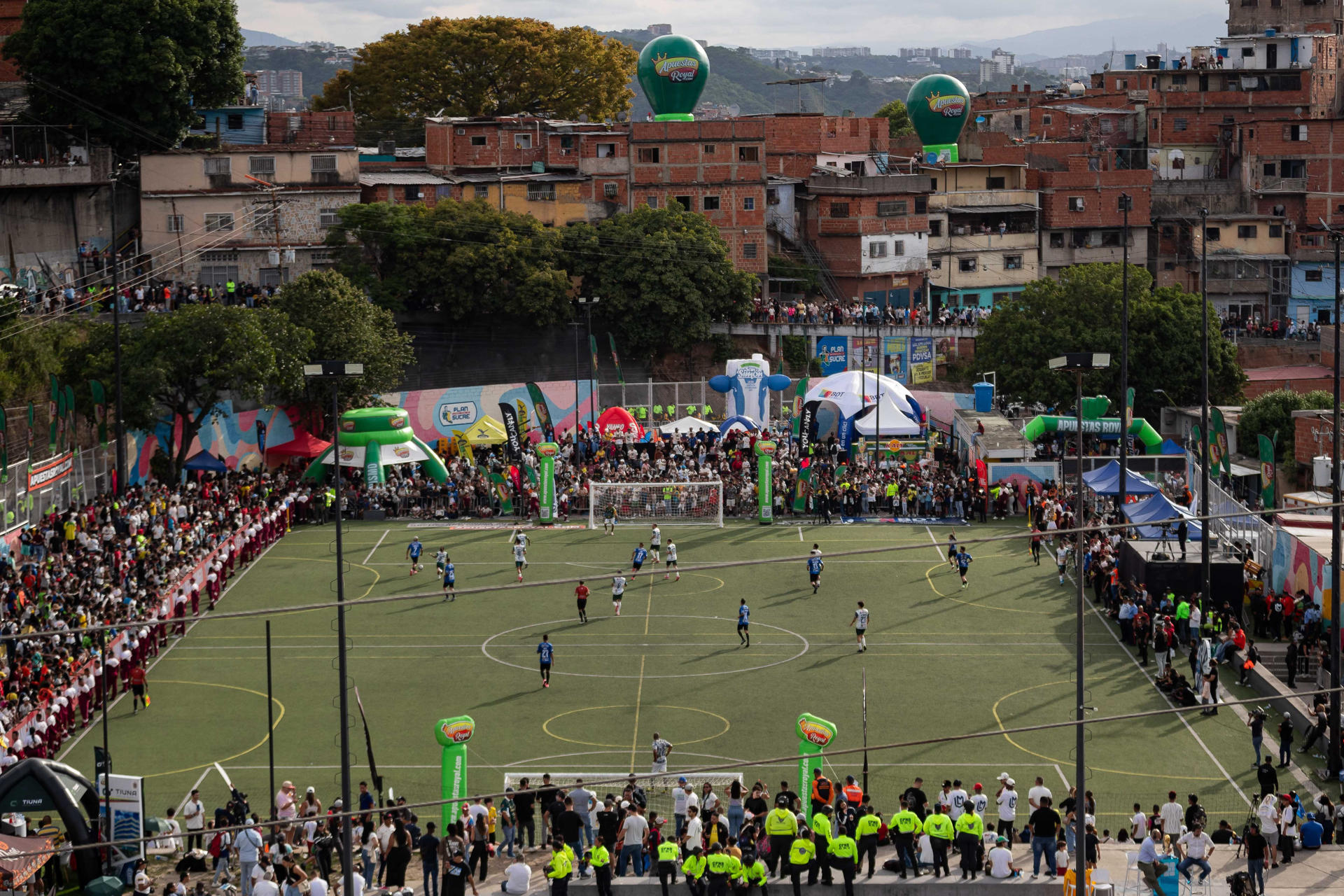 Fotografía que muestra a un grupo de personas observando un partido de exhibición en el que participa el exfutbolista brasileño Ronaldinho, este sábado en Caracas. EFE/ Ronald Peña
