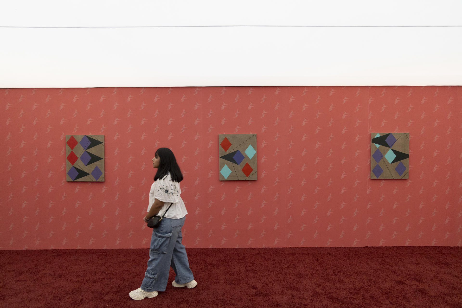 Una mujer recorre la muestra ‘El que la cambia la falla’ este sábado en el Museo de Arte de Zapopan (Guadalajara, México). con los coloridos uniformes del exarquero mexicano Jorge Campos. EFE/ Francisco Guasco
