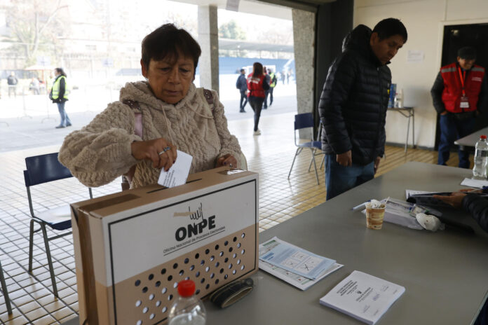 AME9425. SANTIAGO (CHILE), 07/06/2026.- Una mujer deposita su voto en una urna este domingo, durante la segunda vuelta de las elecciones presidenciales en Perú, en Santiago (Chile). EFE/ Elvis González
