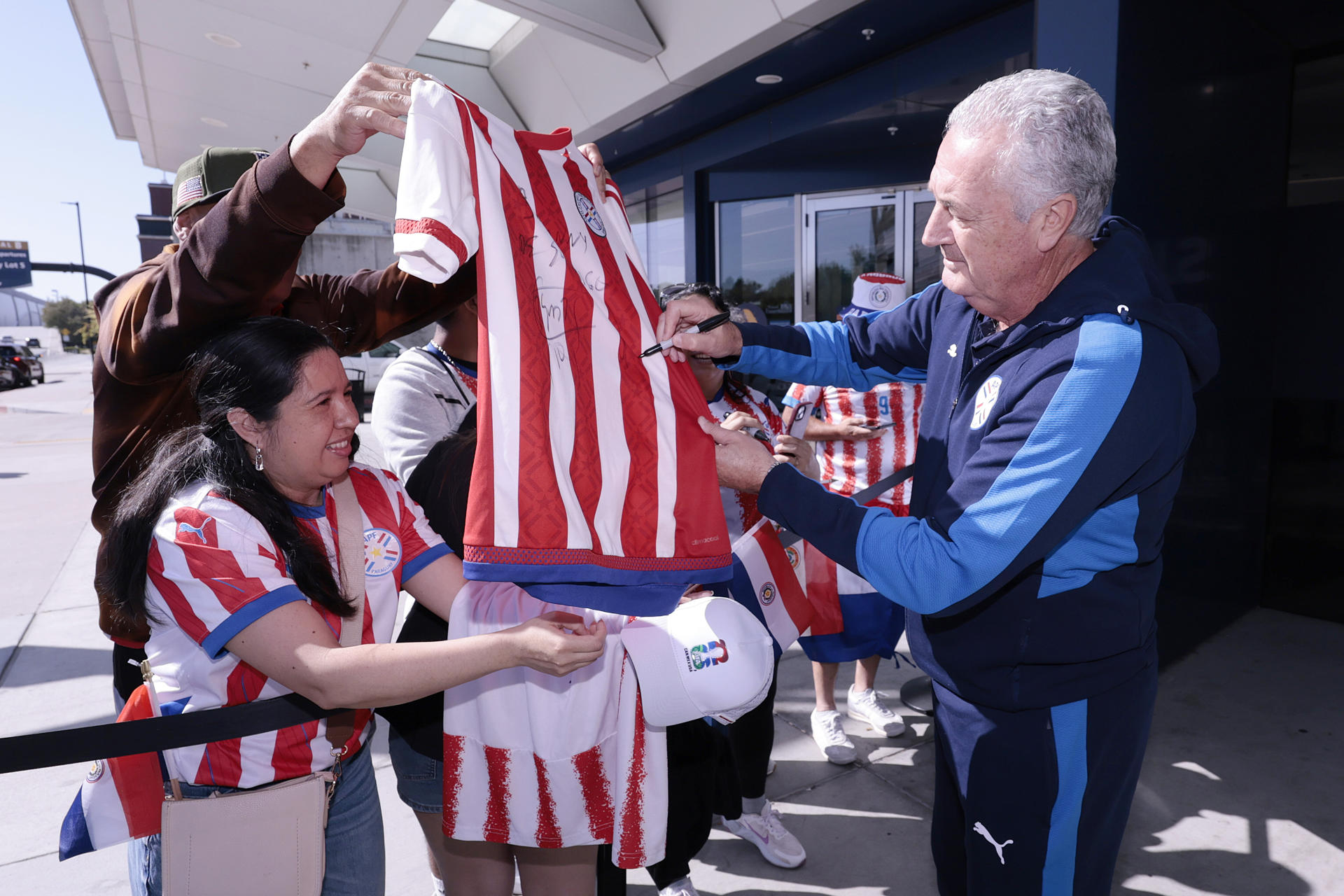 Fotografía cedida por la Asociación Paraguaya de Fútbol (APF) del seleccionador de Paraguay, Gustavo Alfaro, firmando autógrafos a su llegada este domingo a San José (EE.UU). EFE/ Asociación Paraguaya de Fútbol (APF)