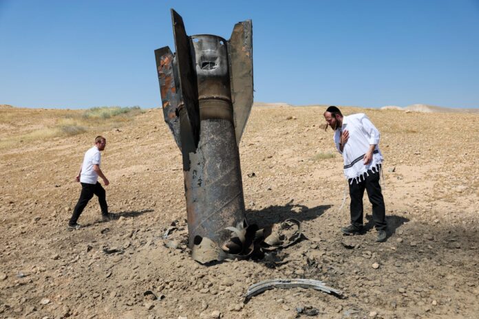 Judíos ultraortodoxos observan los restos de un misil balístico iraní que aterrizó en un campo abierto junto al asentamiento de Cisjordania de Mevo'ot Yericho en el Valle del Jordán, este lunes 8 de junio de 2026. Irán lanzó misiles contra Israel en represalia por un ataque israelí anterior en el suburbio meridional de Beirut. (Jordania) EFE/EPA/ABIR SULTAN
