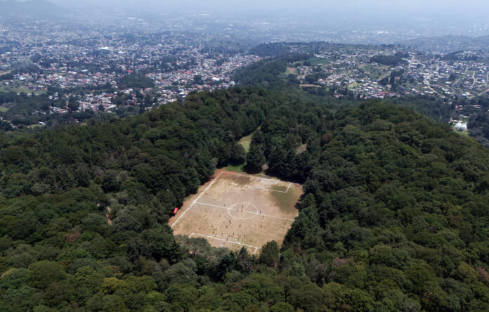 Fotografía aérea que muestra una cancha de fútbol en el cráter de un volcán inactivo este domingo, en Ciudad de México (México). EFE/Tomás Pérez

