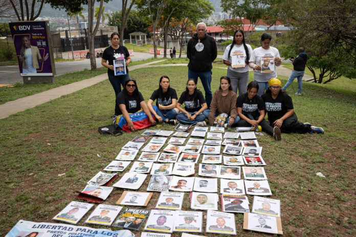 Familiares de presos políticos aguardan con carteles este lunes, en las inmediaciones de la Embajada de Estados Unidos en Caracas (Venezuela).EFE/ Ronald Peña
