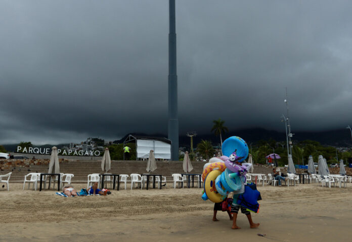 Vendedores camina en una playa de Acapulco (México). Imagen de archivo. EFE/David Guzmán
