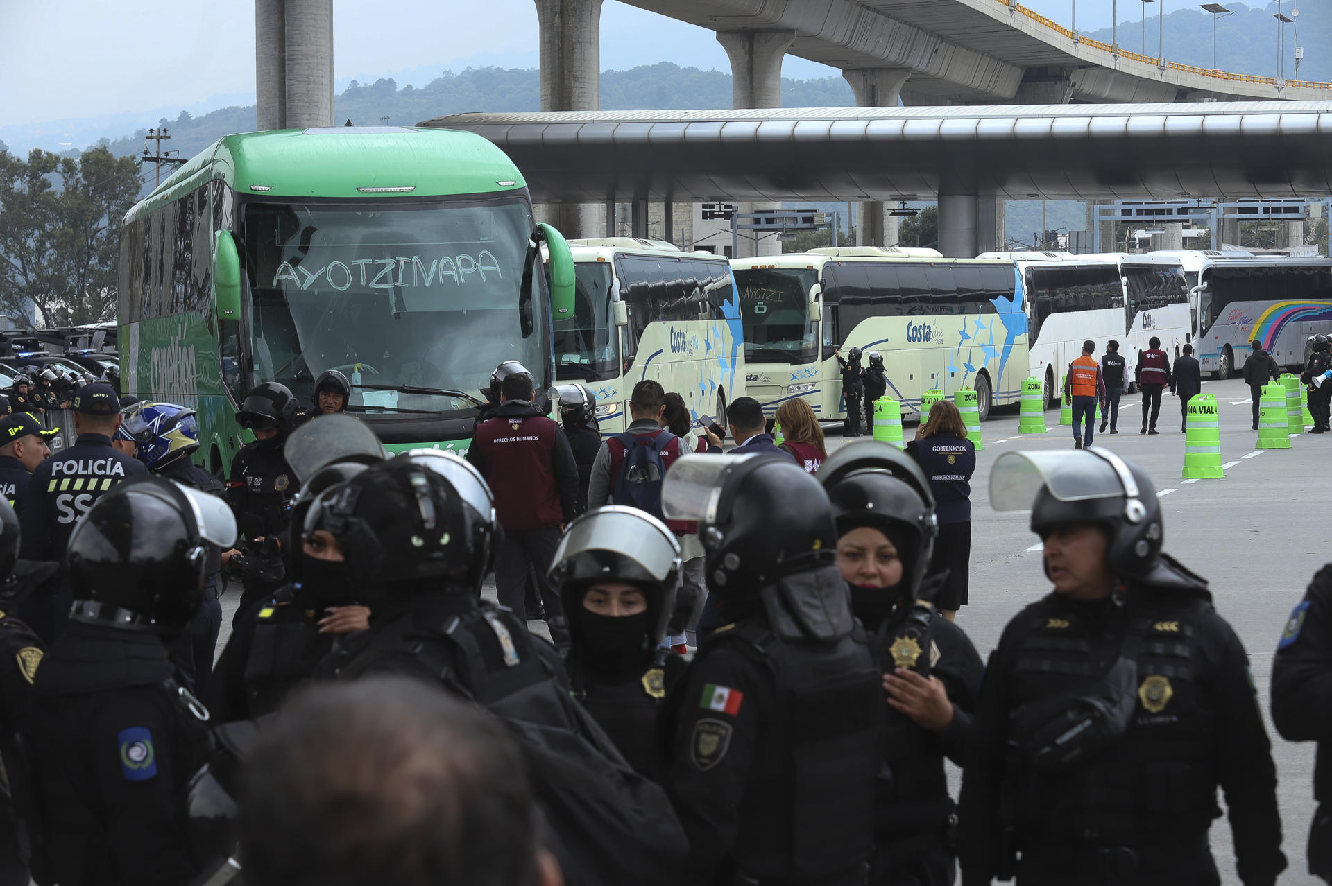 Integrantes de la Secretaría de Seguridad de México bloquean el paso de buses donde viajan estudiantes de Ayotzinapan que se dirigen al Zócalo para manifestarse junto a la Coordinación Nacional de Trabajadores de la Educación (CNTE) este lunes, en el peaje de Tlalpan, al sur de la Ciudad de México (México). EFE/ Madla Hartz
