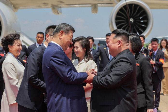 El líder norcoreano, Kim Jong-un (d), saluda al presidente chino, Xi Jinping. Durante la reunión mantenida el lunes, que formó parte de la primera visita de Xi a Corea del Norte en siete años, los líderes acordaron abrir 