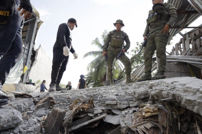Soldados del ejército filipino inspeccionan los daños en el lugar donde se derrumbó un muro que separaba un almacén de varias viviendas, un día después del terremoto, en la ciudad de General Santos, al sur de Filipinas EFE/EPA/CERILO EBRANO
