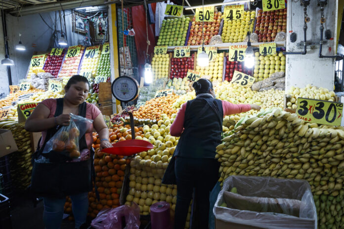 Fotografía del 23 de diciembre de 2025 que muestra a una comerciante atendiendo un local en la Central de Abastos, en Ciudad de México (México).  EFE/ José Méndez
