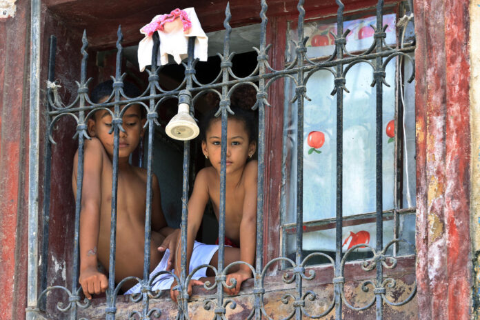 Fotografía del 5 de junio de 2026 que muestra a niños mirando desde una ventana en La Habana (Cuba). Los patios de colegio en La Habana están extrañamente silenciosos este junio. Sin transporte ni alimentos para los comedores, el fin del curso escolar se ha adelantado a la fuerza por la intensificación de la crisis derivada del bloqueo petrolero de EE.UU. EFE/ Ernesto Mastrascusa
