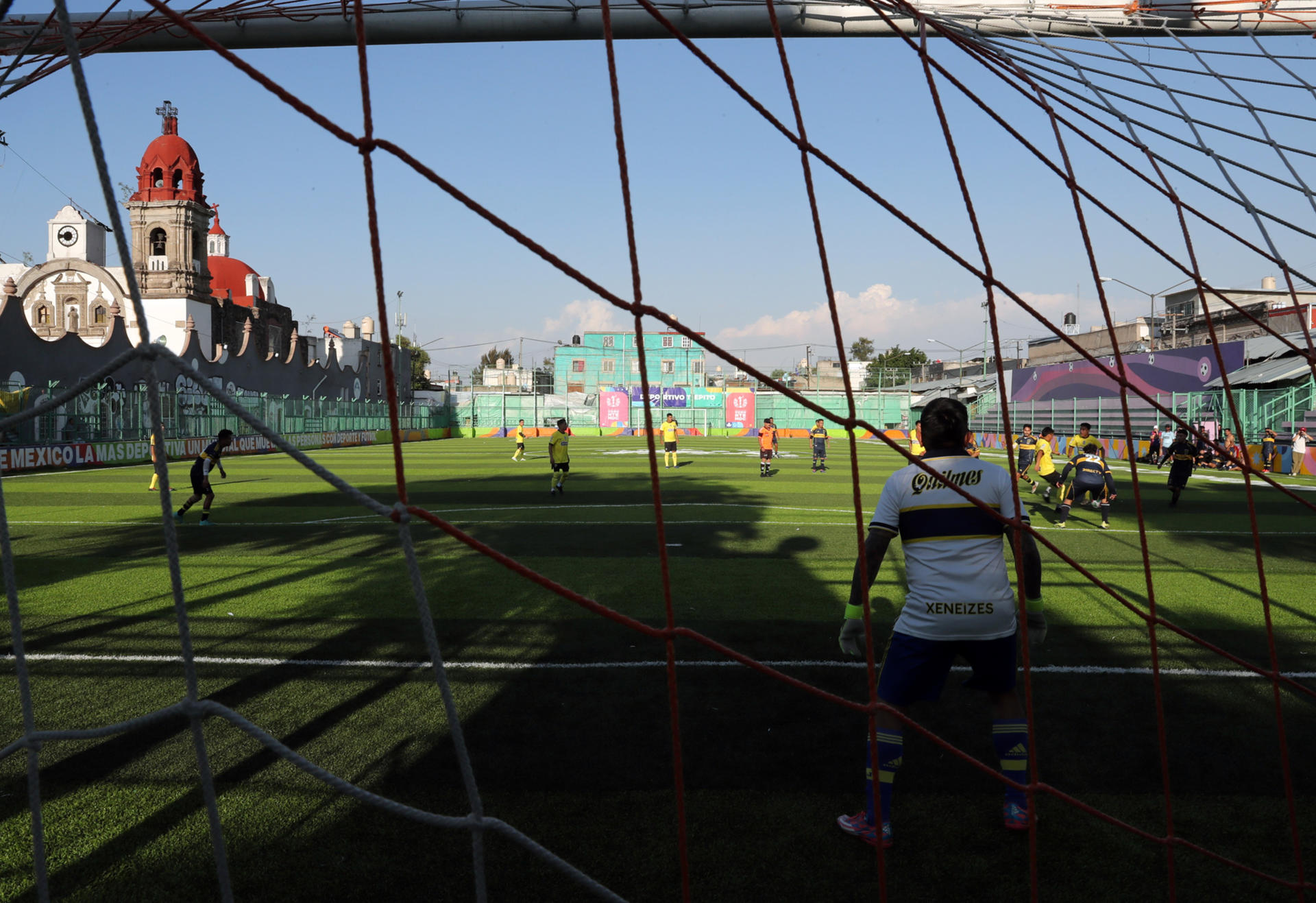 Personas juegan fútbol en una cancha ubicada en el barrio bravo de Tepito este lunes, en Ciudad de México (México). EFE/Mario Guzmán
