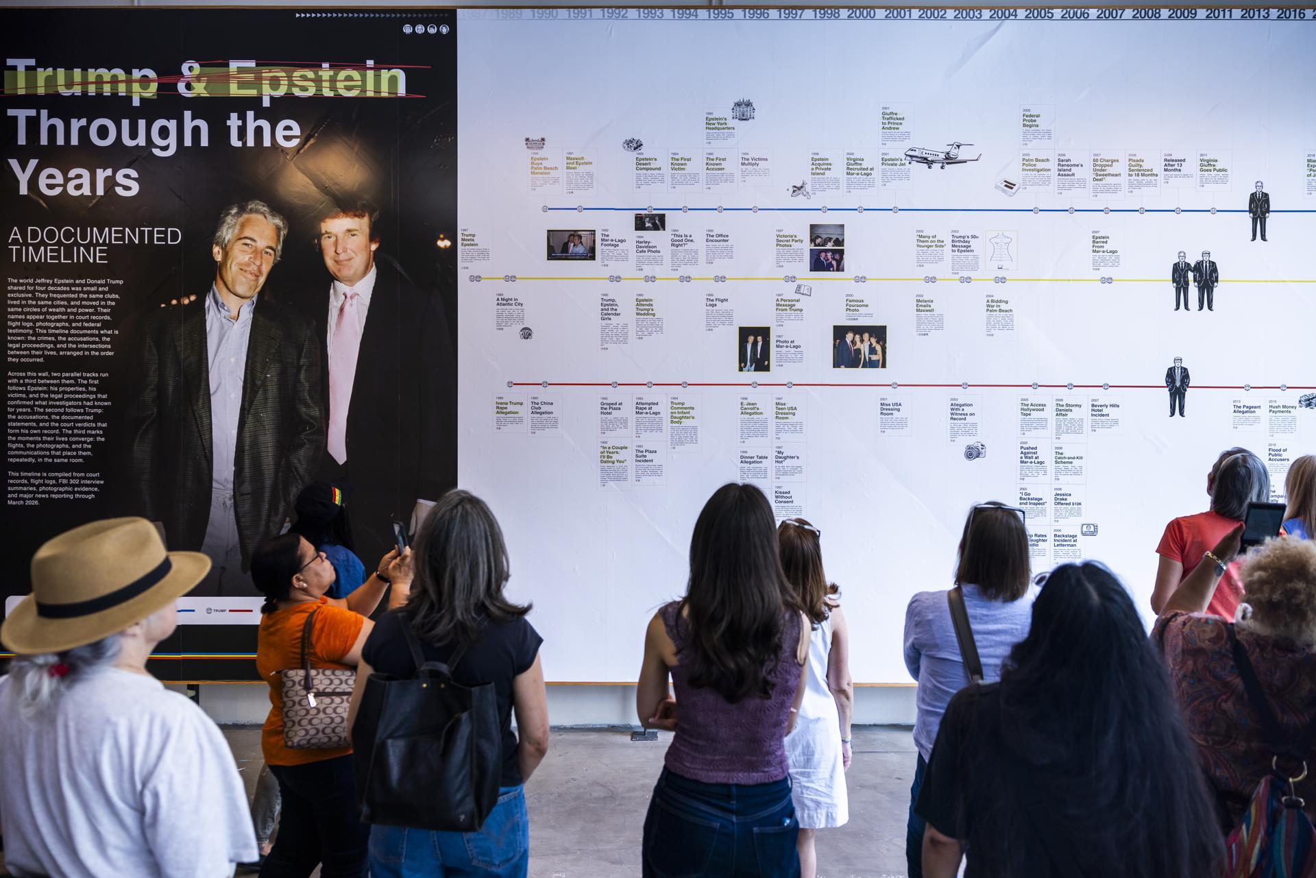 Varias personas observan una cronología de la relación del presidente estadounidense, Donald Trump, con Jeffrey Epstein en la "Sala de Lectura en Memoria de Donald J. Trump y Jeffrey Epstein" el día de la inauguración de la exposición en Washington, DC, EE. UU., el 9 de junio de 2026. EFE/EPA/JIM LO SCALZO