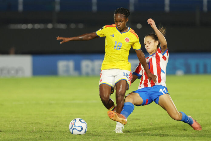 La colombiana Linda Caicedo (i) deja en el camino a la paraguaya Claudia Martínez este martes en un partido de la Liga de Naciones en el estadio Defensores del Chaco, en Asunción. EFE/Juan Pablo Pino
