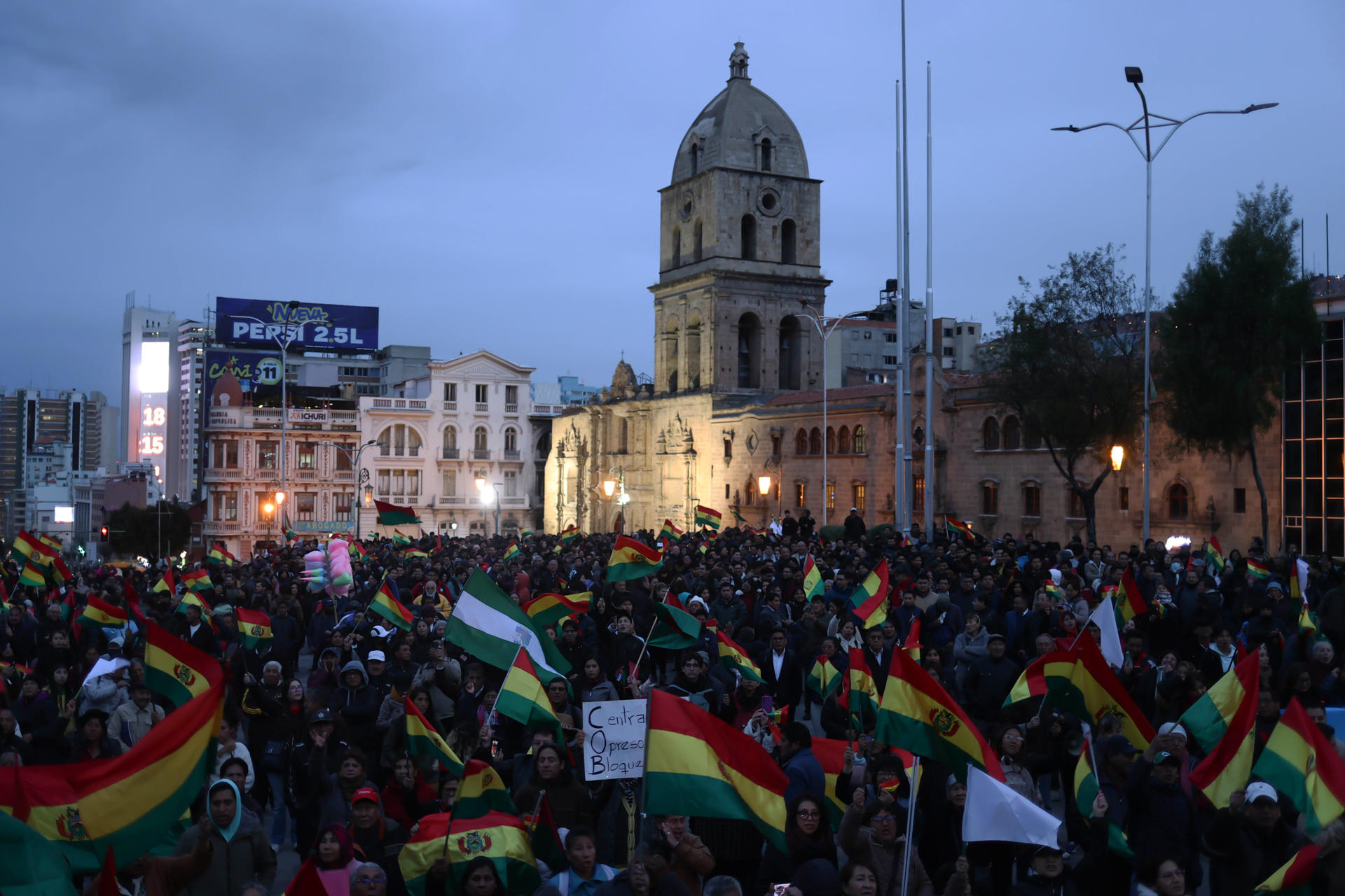 Personas sostienen banderas durante un cabildo donde exigen al gobierno declarar estado de excepción este martes, en el atrio de la basílica de San Francisco en La Paz (Bolivia).EFE/ Luis Gandarillas