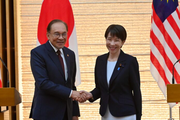 TOKIO (Japón), 10/06/2026.- La primera ministra japonesa, Sanae Takaichi (derecha), y el primer ministro malasio, Anwar Ibrahim (izquierda), se dan la mano al finalizar una rueda de prensa conjunta tras su reunión bilateral en la Oficina del Primer Ministro en Tokio, Japón, el 10 de junio de 2026. 
EFE/EPA/DAVID MAREUIL / POOL
