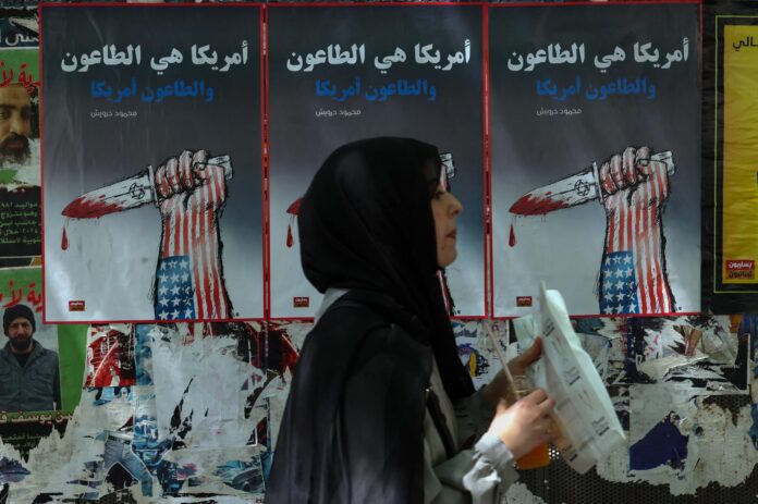 - Una mujer pasa junto a carteles políticos colgados en la pared en una calle de Beirut, Líbano, 09 de junio de 2026. Los carteles representan una mano decorada con los colores de la bandera estadounidense sosteniendo una daga que simboliza a Israel y que dice 'América es una plaga, y la plaga es América'. El Ministerio de Salud libanés dijo que, hasta el 8 de junio, los ataques israelíes en todo el Líbano han matado a más de 3.637 personas y herido a más de 11.188 desde que se reanudaron las hostilidades entre Israel y Hezbolá. (Líbano, Hizbulá/Hezbolá) EFE/EPA/WAEL HAMZEH
