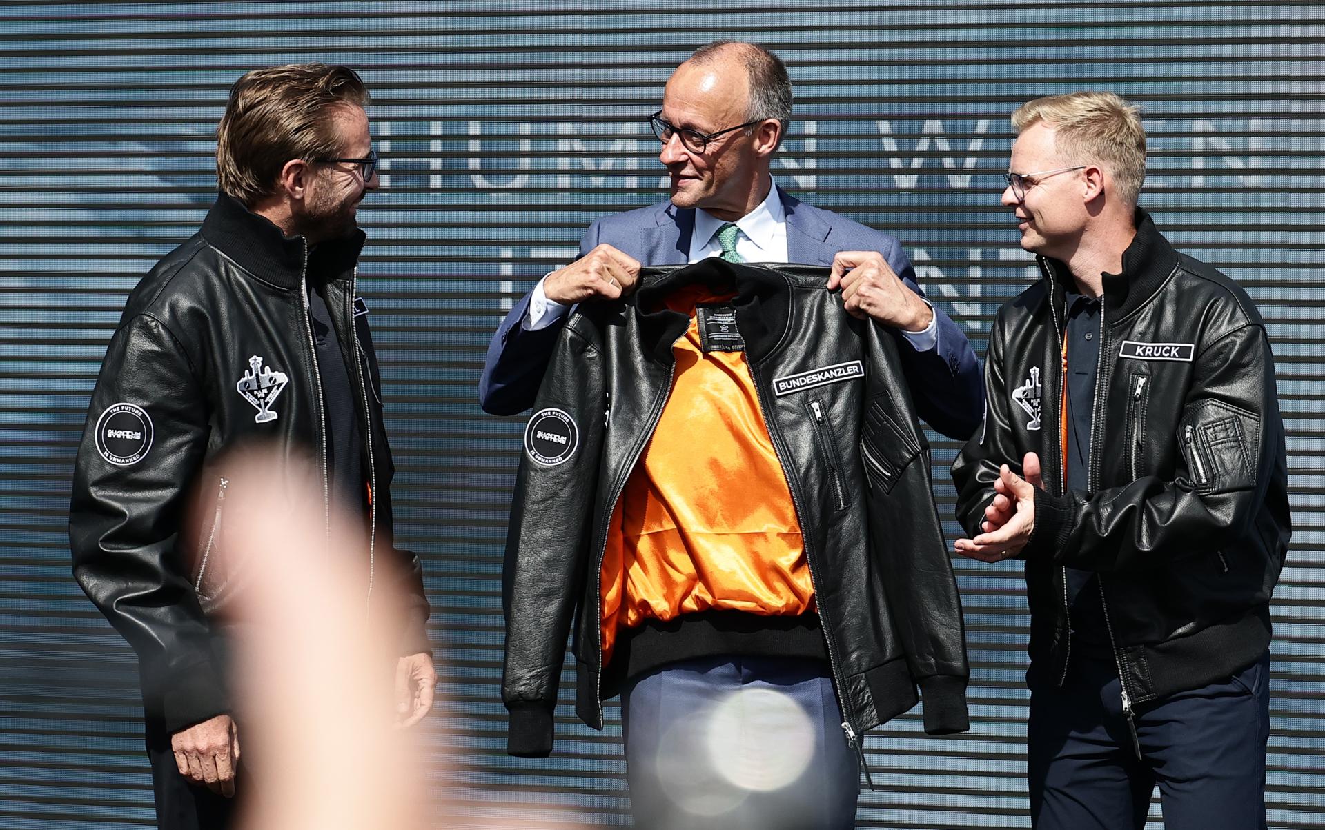El canciller alemán Friedrich Merz sostiene una chaqueta de vuelo con un parche que dice “Bundeskanzler” durante la inauguración del Salón Aeronáutico ILA de Berlín 2026 en Schoenefeld, Alemania, el 10 de junio de 2026. La exposición de la industria aeroespacial y de defensa tiene lugar en el aeropuerto de Berlín-Brandeburgo del 10 al 14 de junio de 2026. (Alemania) EFE/EPA/FILIP SINGER