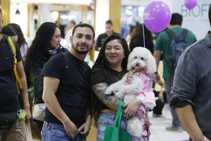 Fotografía tomada el pasado 30 de mayo en la que se captó a una pareja al posar con un perro, durante la feria 'Expo Mascotas & Animales', en Santiago de Chile. EFE/Elvis González

