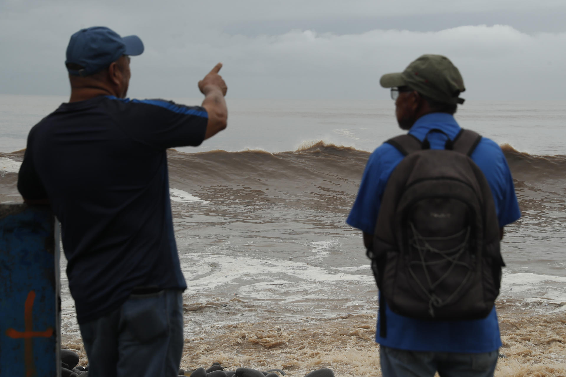 Personas observan el oleaje en el Puerto de La Libertad este miércoles, en La Libertad (El Salvador). EFE/ Rodrigo Sura
