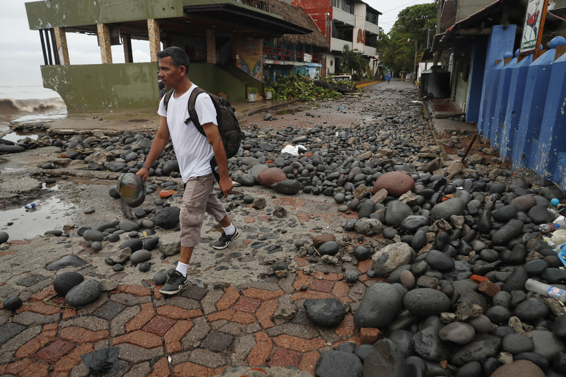 Una persona camina entre piedras desbordadas por el oleaje en el Puerto de La Libertad este miércoles, en La Libertad (El Salvador). EFE/ Rodrigo Sura
