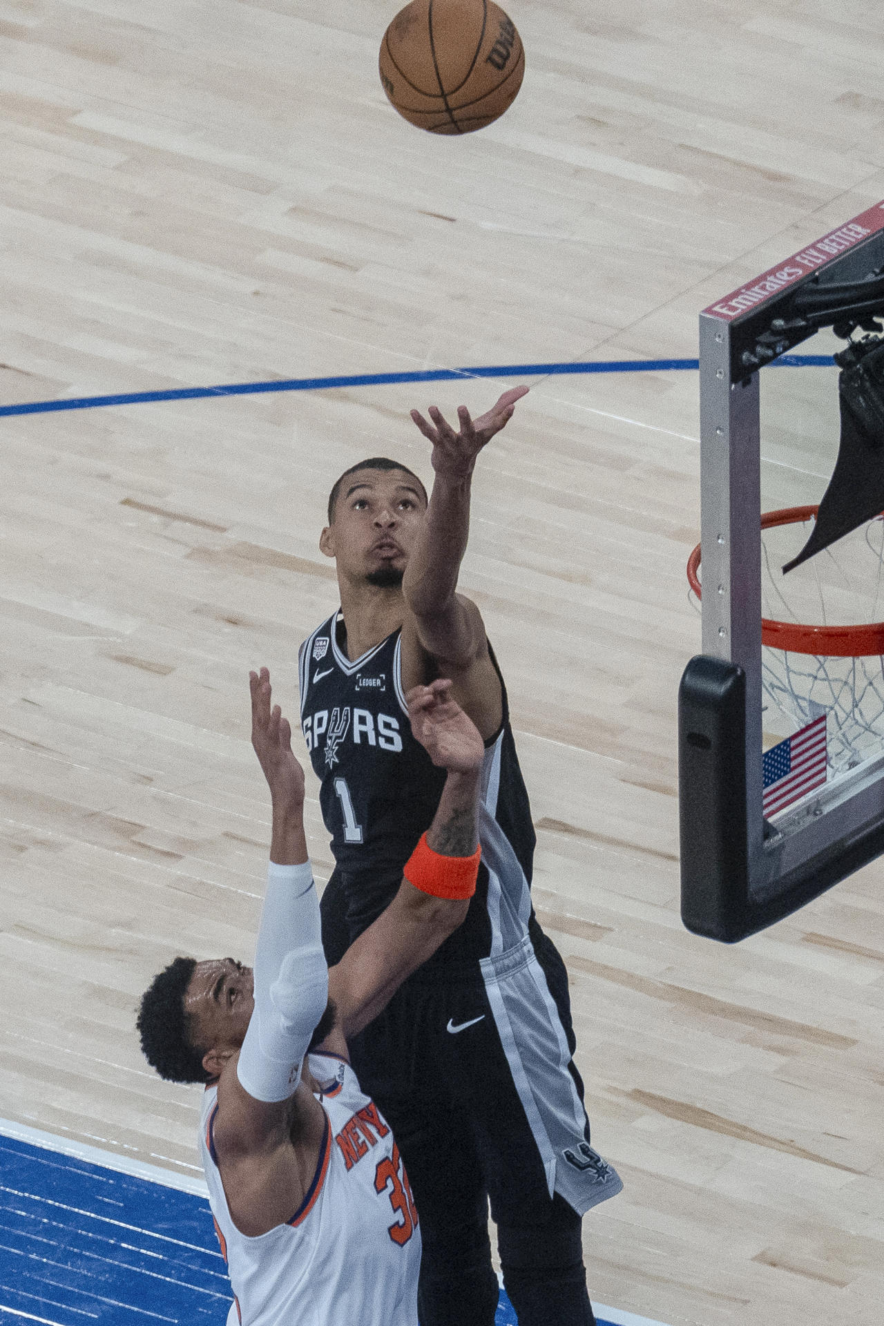 Karl-Anthony Towns (abajo) de Knicks pierde en el salto por el balón con Victor Wembanyama de Spurs, este miércoles durante el cuarto partido de las finales de la NBA en el Maidson Square Garden de Nueva York. EFE/ Ángel Colmenares