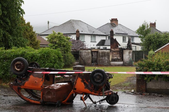 Una casa y un vehículo calcinados tras una noche de violentos disturbios en Antrim Road, Newtownabbey, Irlanda del Norte, 11 de junio de 2026. EFE/EPA/ADAM VAUGHAN
