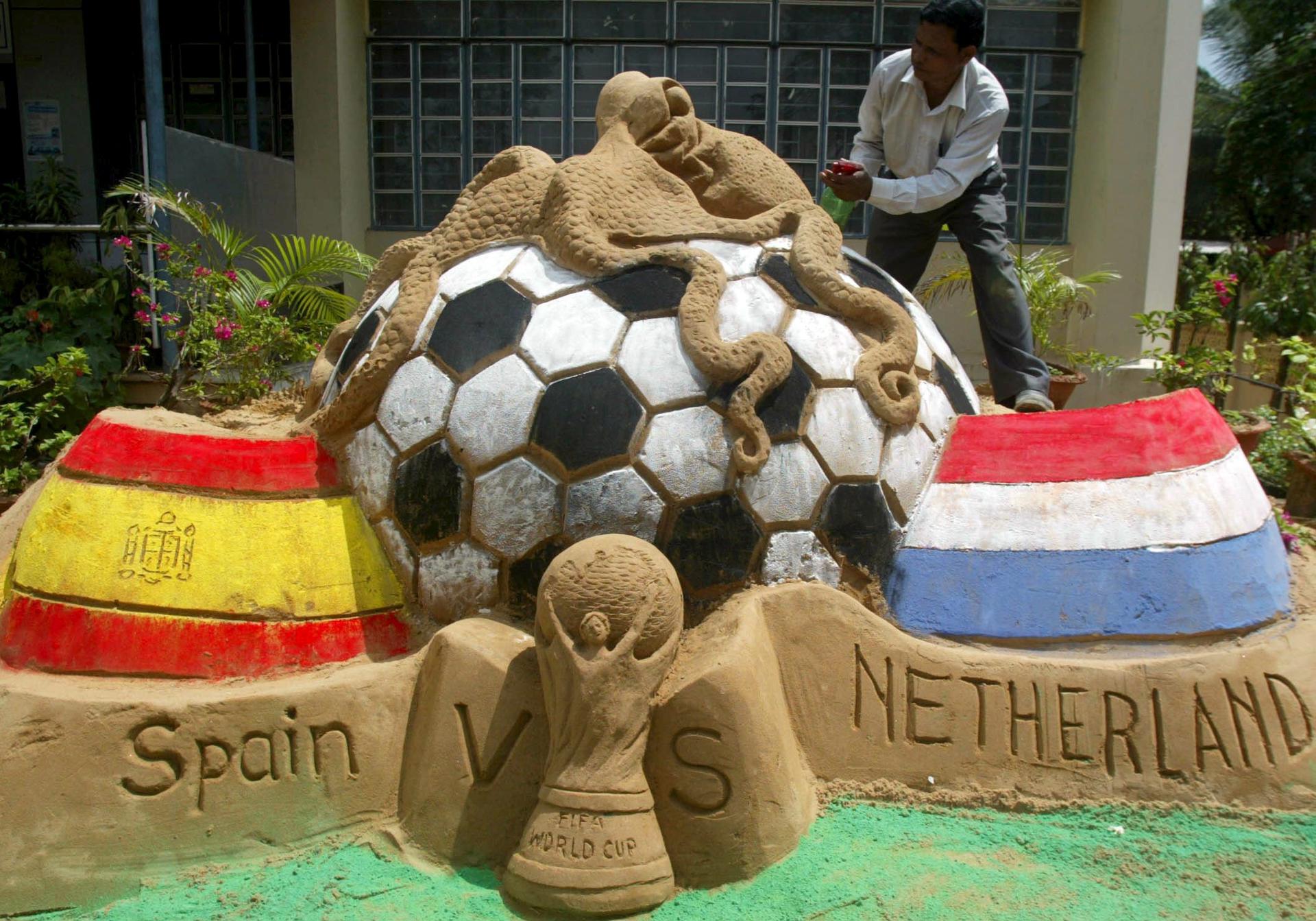 Fotografía de archivo del 10 de julio de 2010, en la que puede verse una escultura de arena del artista indio Subal Maharanada representando las banderas de España y Holanda, la copa del Mundo de fútbol y al pulpo Paul sobre un balón gigante. EFE
