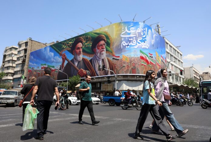 Ciudadanos iraníes pasan junto a una gran valla publicitaria con la imagen del difunto líder supremo iraní, el ayatolá Ruhollah Khomeini, y del líder supremo, el ayatolá Ali Khamenei, en una calle de Teherán, Irán, este miércoles. Según el Comando Central de Estados Unidos (CENTCOM), el 9 de junio se llevaron a cabo ataques de autodefensa contra Irán cerca del estrecho de Ormuz en respuesta al derribo de un helicóptero Apache del Ejército estadounidense. (Teherán) EFE/EPA/ABEDIN TAHERKENAREH RESTRICCIONES: Prohibido el acceso a medios de comunicación israelíes/canales de televisión en persa fuera de Irán/Estrictamente prohibido el acceso a BBC Persian/VOA Persian/Manoto TV/Televisión Internacional de Irán. (Según lo dispuesto por la Dirección General de Medios de Comunicación Extranjeros de Irán)
