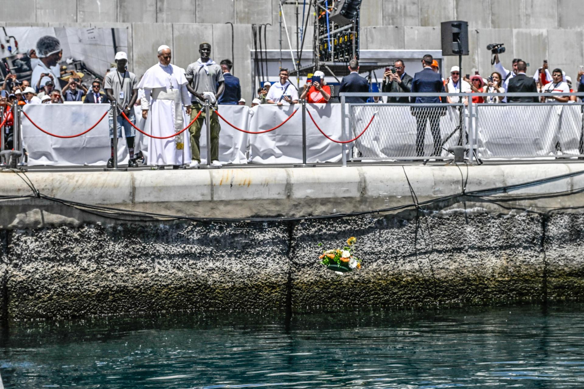 .- El Papa León XIV, con dos migrantes flanqueándolo, arroja una corona de flores al mar en homenaje a los migrantes que murieron intentando llegar a territorio español durante su reunión con organizaciones que trabajan con inmigrantes en el Puerto de Arguineguín en Gran Canaria, Islas Canarias, España, 11 de junio de 2026. El Papa León XIV visita España del 06 al 12 de junio de 2026, con paradas en Madrid, Barcelona y las Islas Canarias. (Papa, España) EFE/EPA/CIRO FUSCO
