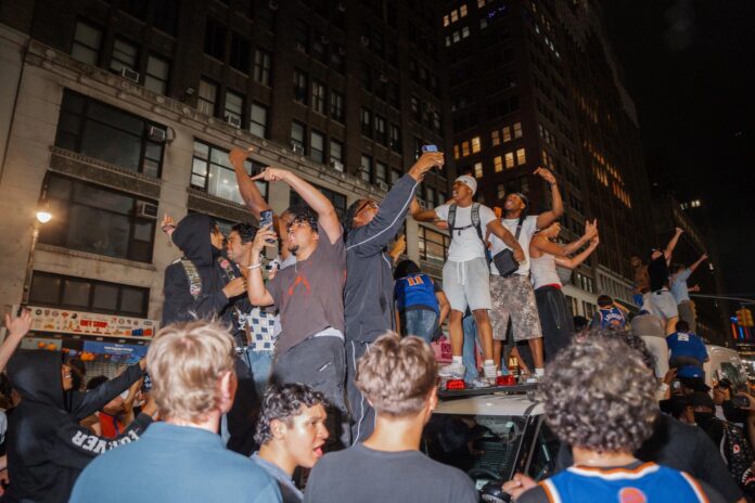 Aficionados de los Knicks saltan sobre un coche patrulla durante las celebraciones tras la victoria de los New York Knicks sobre los San Antonio Spurs en el cuarto partido de las Finales de la NBA, en Nueva York, Nueva York) EFE/EPA/OLGA FEDOROVA
