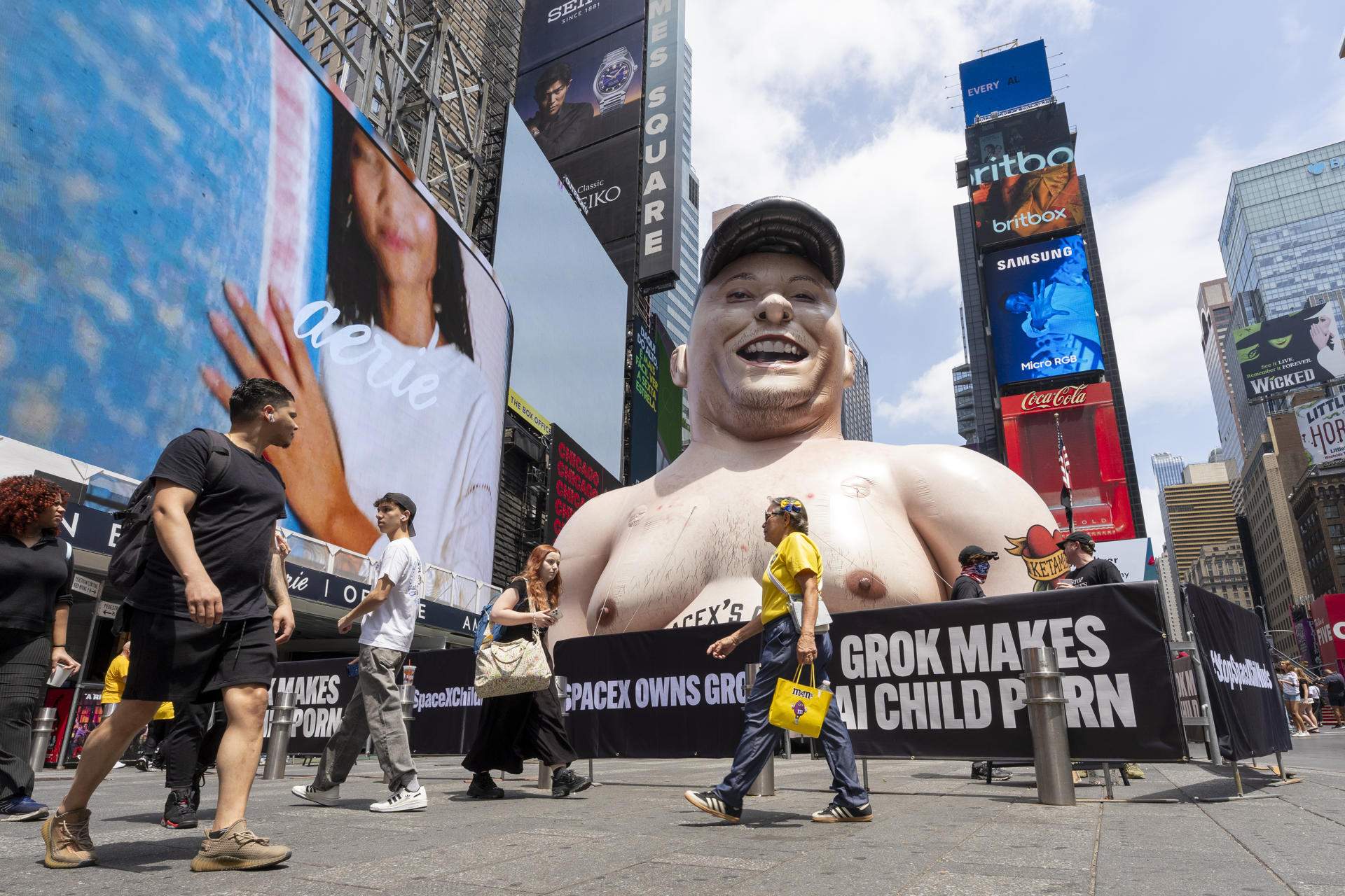Personas se manifiestan por el lanzamiento a la bolsa de SapaceX frente a un muñeco inflable gigante con la cara de Elon Musk este jueves, en Times Square de Nueva York (EE.UU.). EFE/ Ángel Colmenares
