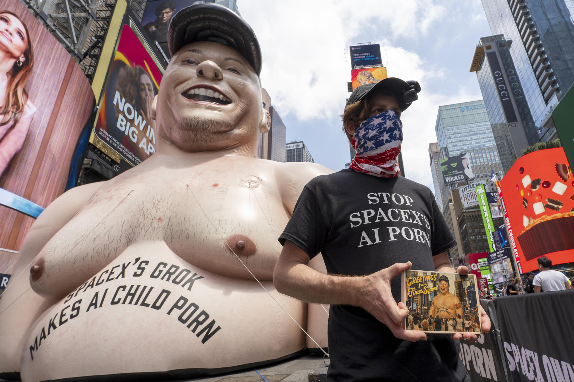 Una persona se manifiesta por el lanzamiento a la bolsa de SapaceX frente a un muñeco inflable gigante con la cara de Elon Musk este jueves, en Times Square de Nueva York (EE.UU.). EFE/ Ángel Colmenares
