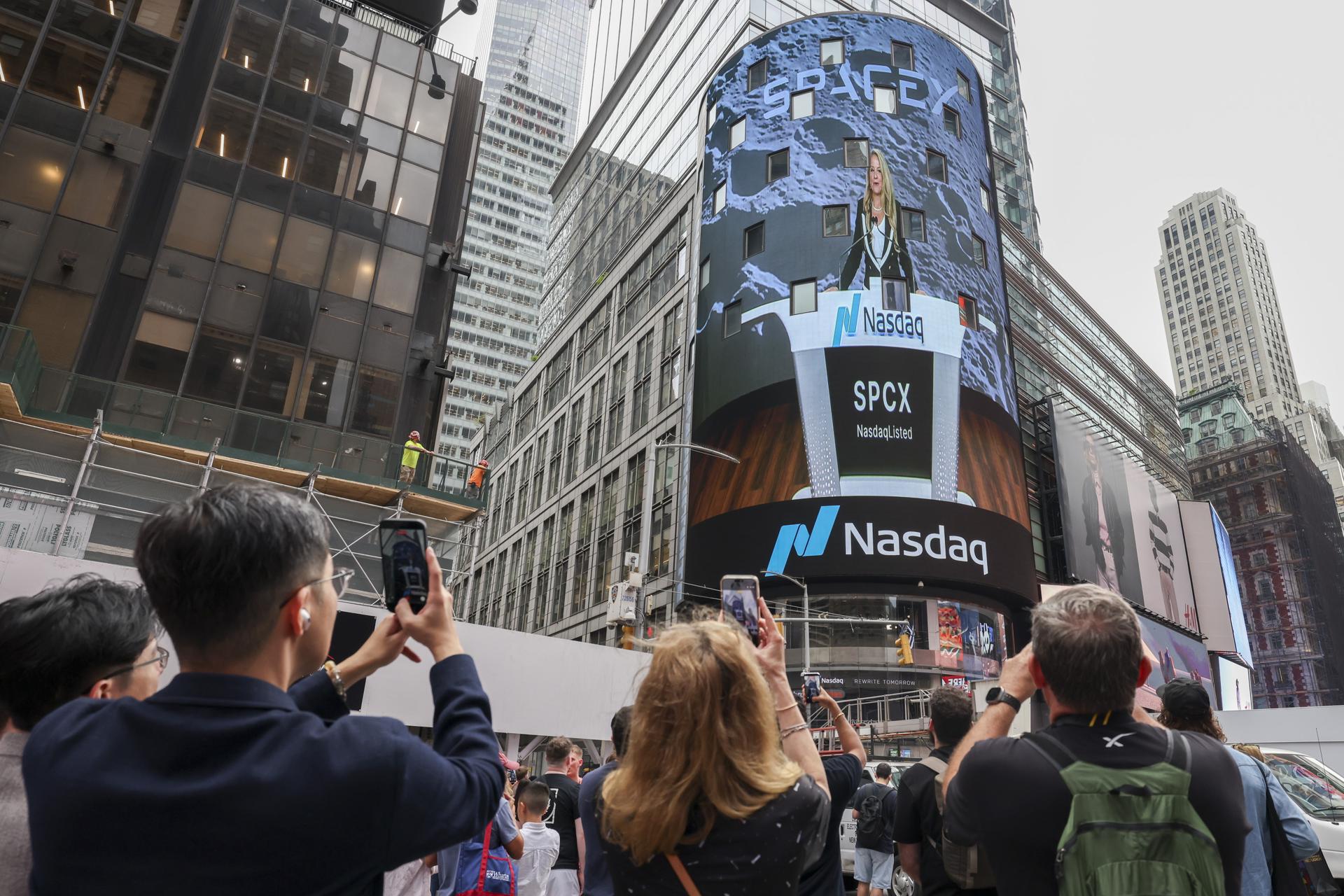 Decenas de personas fueron captadas este 12 de junio al observar la pantallas gigantes de la sede del indicador bursátil Nasdaq, durante el entrada a bolsa de la compañía aeroespacial SpaceX, en Times Square (NY, EE.UU.). EFE/Sarah Yenesel
