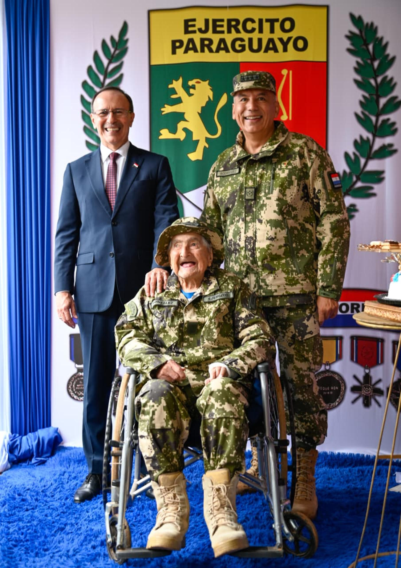 Fotografía cedida este 12 de junio por el Ministerio de Defensa de Paraguay en la que se captó al jefe de la cartera, Óscar González (i), y al comandante del Ejército, general Manuel Rodríguez (d), al posar junto al excombatiente de la Guerra del Chaco Canuto González (c), durante el aniversario 91 del Protocolo de Paz entre Paraguay y Bolivia, en San Lorenzo (Paraguay). EFE/Ministerio de Defensa de Paraguay
