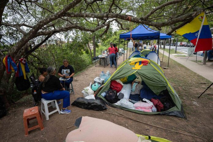 Familiares de presos políticos esperan en un campamento frente a la embajada de los Estados Unidos este viernes, en Caracas (Venezuela). EFE/ Ronald Peña
